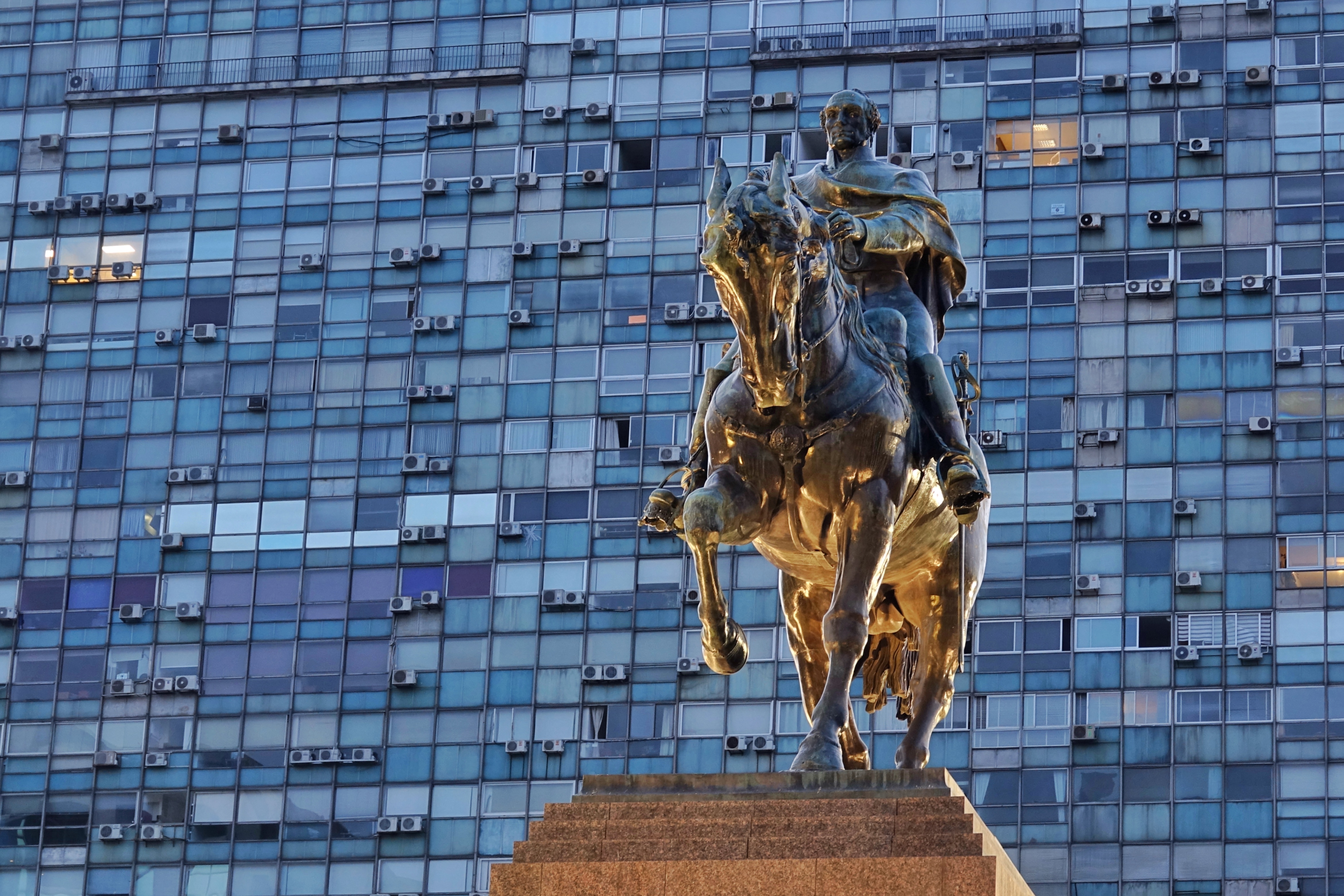 Statue équestre devant une façade vitrée